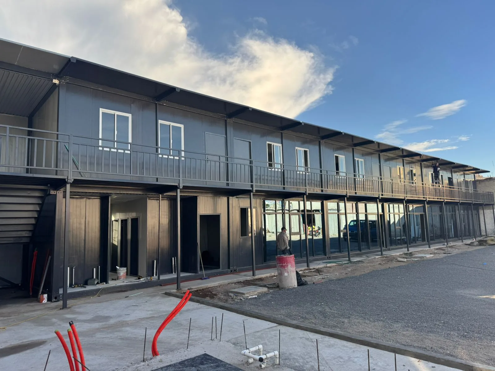 Edificio modular corporativo de dos niveles con pasillo en acero negro — megacampus logístico