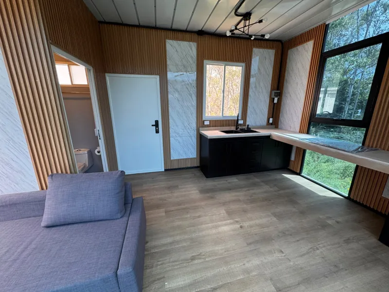 Cocineta con tarja doble, barra y ventanal hacia el jardín