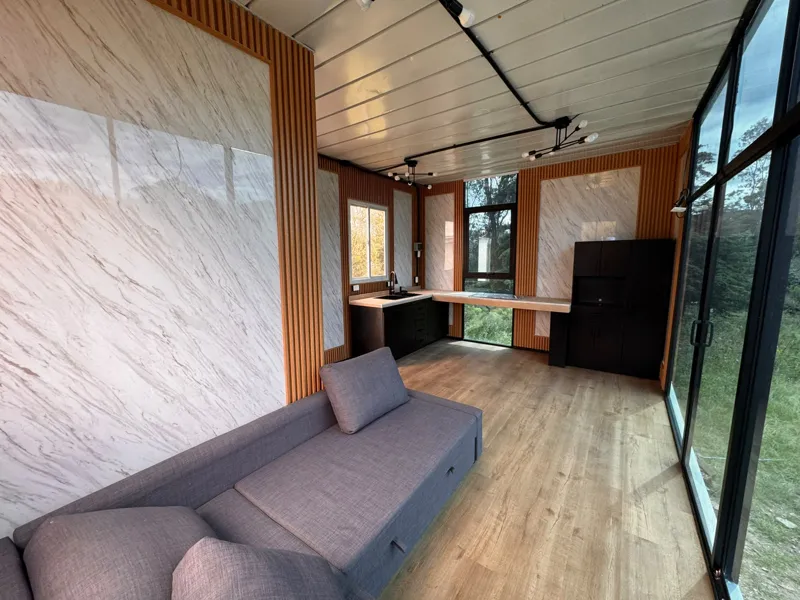Sala con muro tipo mármol, lambrín de madera y cancelería de piso a techo